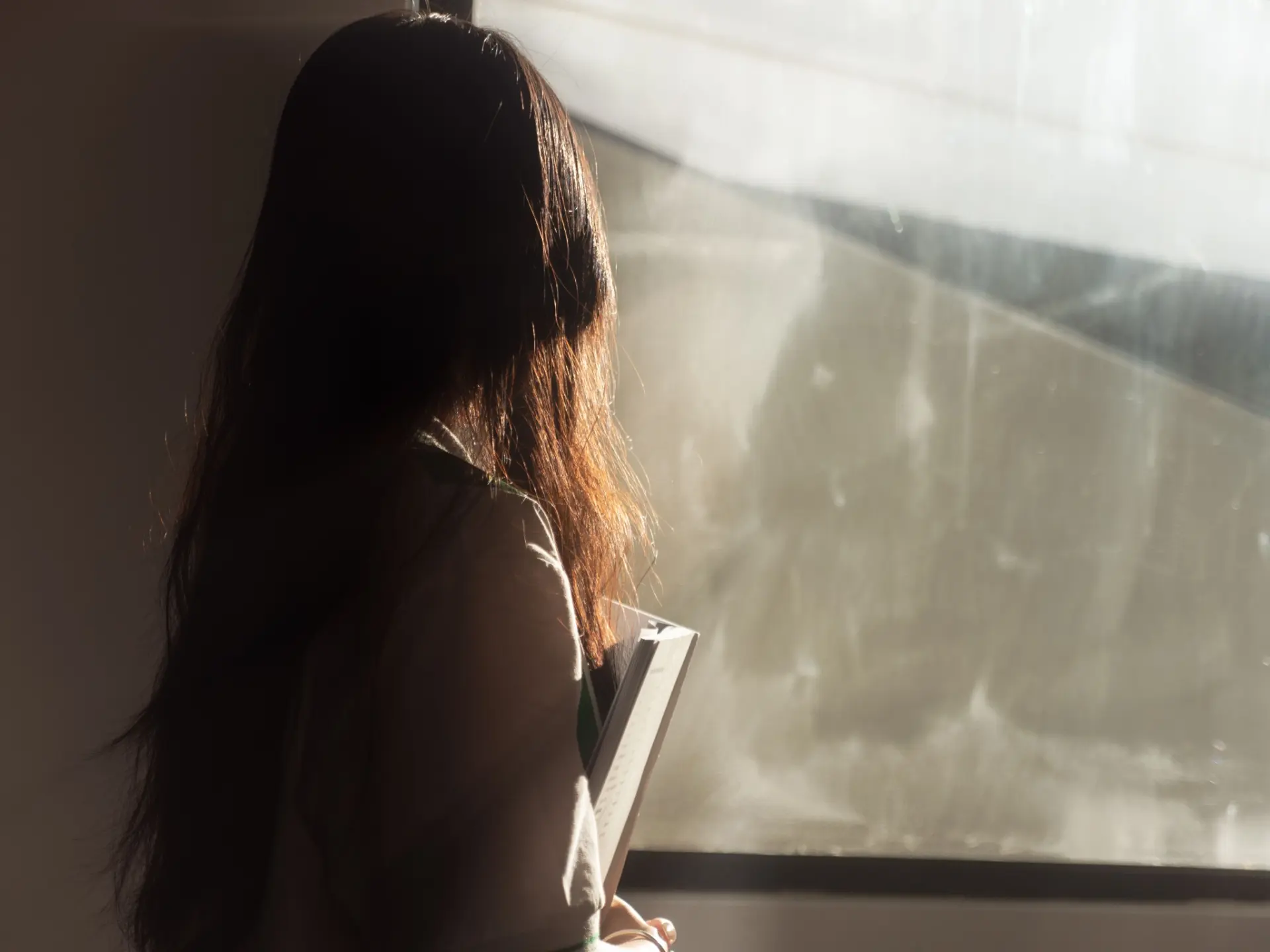 Woman looking thoughtfully out of a window in the morning
