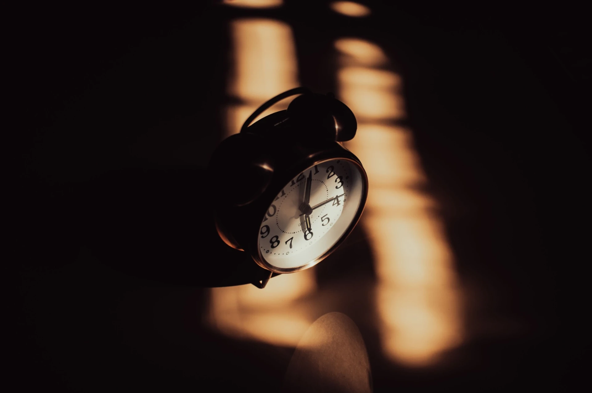 Alarm clock in a dark bedroom on an autumn morning